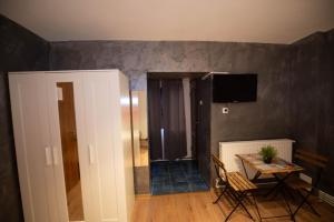 a room with a table and a television on a wall at Vila Estera Therme Balotesti in Baloteşti