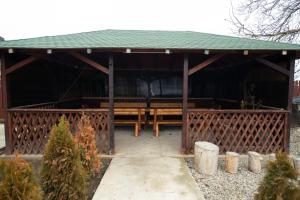 a wooden gazebo with a green roof at Vila Estera Therme Balotesti in Baloteşti