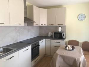 a kitchen with white cabinets and a plate of food on a table at Cosy Apartment with beautiful terrace in the heart of Varna in Varna City