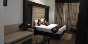 a hotel room with a bed and a couch at HOTEL PITRASHISH PRIDE IGI Intl AIRPORT DELHI in New Delhi