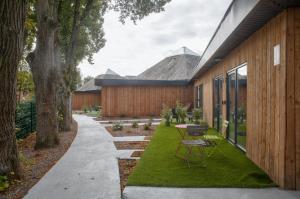 a garden with a table and chairs next to a building at Domaine des 3 Villages in Bouchemaine