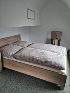ein Schlafzimmer mit einem Bett mit einem Bettrahmen aus Holz in der Unterkunft Störmthal Ferienwohnung 2 Sonnenweg in Großpösna