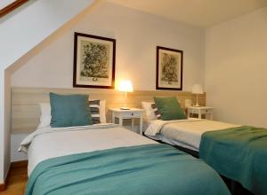a bedroom with two beds with green and white sheets at Rías Altas Home Sada in Sada