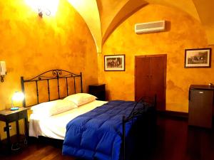 a bedroom with a bed with a blue comforter at Nel Centro Storico in Galatina