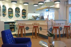 a bar with stools and a counter with wine bottles at Hotel Majestic in Lido di Jesolo +83 photos
