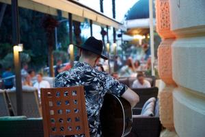 a man sitting in a chair playing a guitar at BRISTOL Hotel Opatija in Opatija
