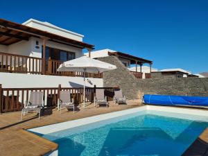 una villa con piscina y una casa en Luxury 4-Bedroom Villa With Heated Pool + Sea View, en Playa Blanca