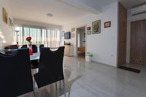 uma sala de jantar com uma mesa e cadeiras pretas em Apartment BELVEDERE Sea View em Medulin