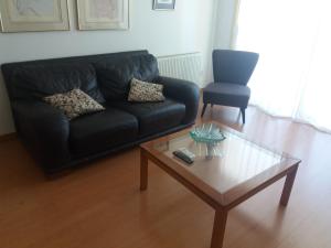 a living room with a black couch and a coffee table at Klimentos Flat 64 in Nicosia