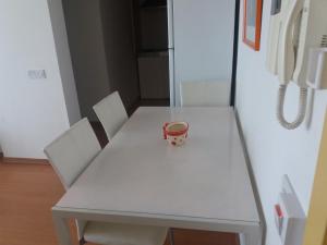 Una mesa blanca con dos sillas y una taza. en Klimentos Flat 64, en Nicosia