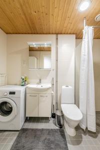 ein Bad mit einem WC, einem Waschbecken und einer Waschmaschine in der Unterkunft SleepWell Apartment Rio with private sauna and parking in Helsinki