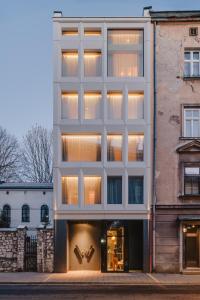 a large white building with a large window at Warszauer Hotel in Kraków