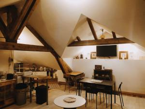 Cette chambre mansardée dispose de tables et de chaises. dans l'établissement Les Bains Douches, à Périgueux
