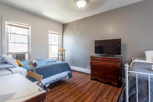 a bedroom with a bed and a flat screen tv at Best Home To Visit NYC-Subway Access in Newark