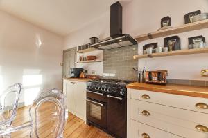 a kitchen with a stove and some chairs in it at Host & Stay - Peacock House in Tynemouth
