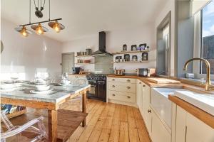 a large kitchen with a wooden floor and white cabinets at Host & Stay - Peacock House in Tynemouth