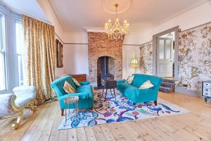 a living room with two blue chairs and a fireplace at Host & Stay - Peacock House in Tynemouth