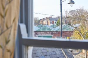 einen Blick aus einem Fenster eines Gebäudes mit einem Schild in der Unterkunft Host & Stay - Peacock House in Tynemouth