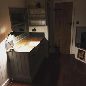 una cocina con una barra con una lámpara. en Bluebell shepherds Hut, en Rolvenden