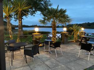a patio area with chairs, tables and umbrellas at The Inn on the Loch in Castle Douglas