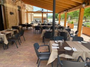 a dining room with tables and chairs and tablesearcher at Albergue La Estación in Cehegín