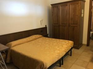 a bedroom with a bed and a wooden cabinet at Agriturismo Aqua Viva in Acquaviva Picena