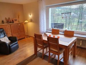 a dining room with a table and chairs and a window at Ferienhaus Junge Ruhr in Olsberg