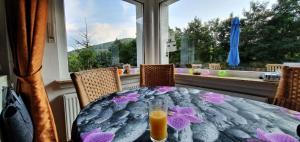 a table with a glass of orange juice on top of it at Ferienhaus Junge Ruhr in Olsberg