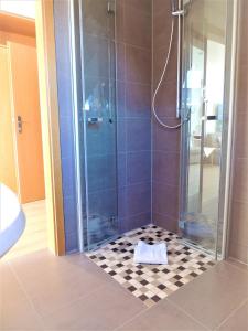 a bathroom with a shower with a tile floor at Gästehaus Jutta / Pension Link in Fladungen