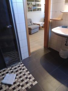 a bathroom with a shower and a tiled floor at Gästehaus Jutta / Pension Link in Fladungen