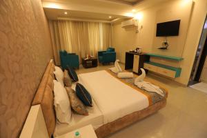 a hotel room with a large bed and a television at Meera Madhav Resort in Vrindāvan