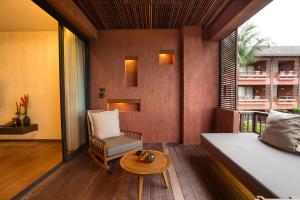 a bedroom with a bed and a chair and a table at Hansar Samui Resort & Spa - SHA Extra Plus in Bophut 