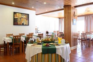 uma sala de jantar com mesas e cadeiras com comida em Hotel Dom Nuno em Santiago do Cacém