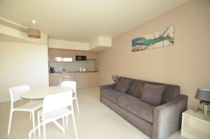 a living room with a couch and a table and chairs at La Perle d'Eze - Aparthotel in Éze