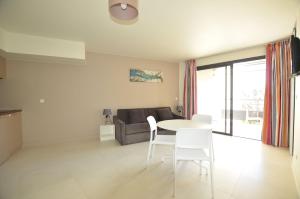 a living room with a table and chairs and a couch at La Perle d'Eze - Aparthotel in Éze