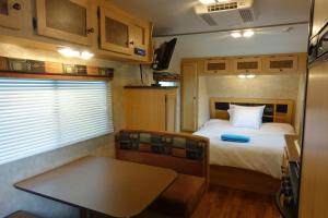 a bedroom with a bed and a table in a trailer at Best XL Home To Visit NYC+Hot Tub+Newark Airport+Free Parking in Hillside