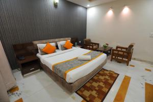 a bedroom with a large bed with orange pillows at Meera Madhav Resort in Vrindāvan
