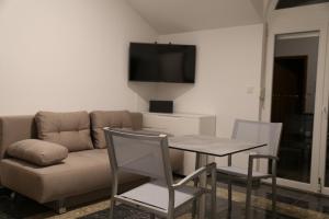 ein Wohnzimmer mit einem Sofa, einem Tisch und Stühlen in der Unterkunft mk apartments nin Wohnung 8 in Kod Mula