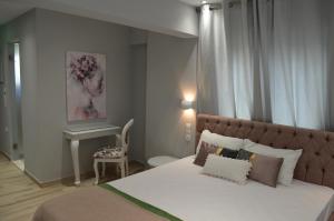 a bedroom with a bed and a table and a chair at kastro luxury studios and mezonette in Skiathos Town