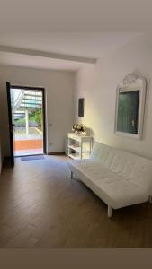 a living room with a white couch and a door at B&B Al Viale in Macerata