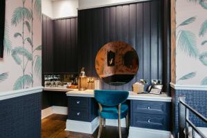 a bar with a blue chair and a mirror at Crown Hotel in Stamford