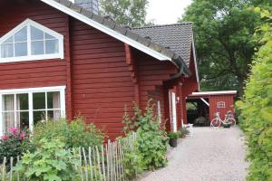 ein rotes Haus mit einem weißen Zaun davor in der Unterkunft Holthus in Kollmar