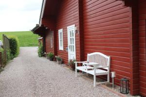a red house with a bench on the side of it at Holthus in Kollmar