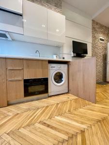 cocina con lavadora y secadora en el suelo de madera en The Bohemian Residence en Belgrado