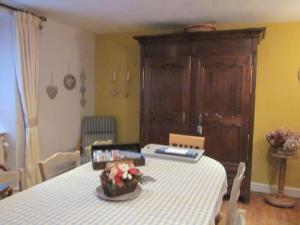 uma sala de jantar com uma mesa com uma toalha de mesa branca em Chambres au calme en Ardenne em Fauvillers