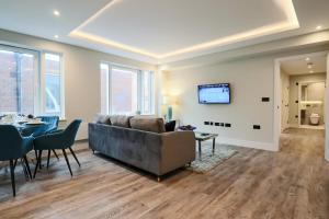 a living room with a couch and a table at Portfolio Apartments - Welwyn Town Centre in Welwyn Garden City