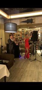 a man and a woman in a living room with a microphone at Hotel Atmosphere in Poltava