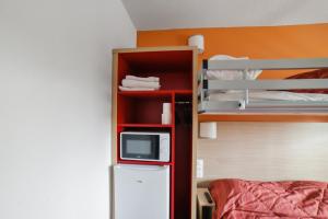 Zimmer mit einem Etagenbett, einer Mikrowelle und einem Kühlschrank. in der Unterkunft Premiere Classe Thionville - Yutz in Basse-Yutz