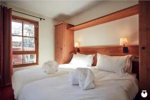 two white beds in a room with a window at Tartiflat, Arc1950, 2 bed, Ski in Ski out, Arc 1950 in Bourg-Saint-Maurice