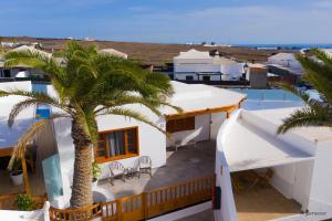 een uitzicht op een huis met een palmboom bij Luxury Villas Anjomacar in Teguise